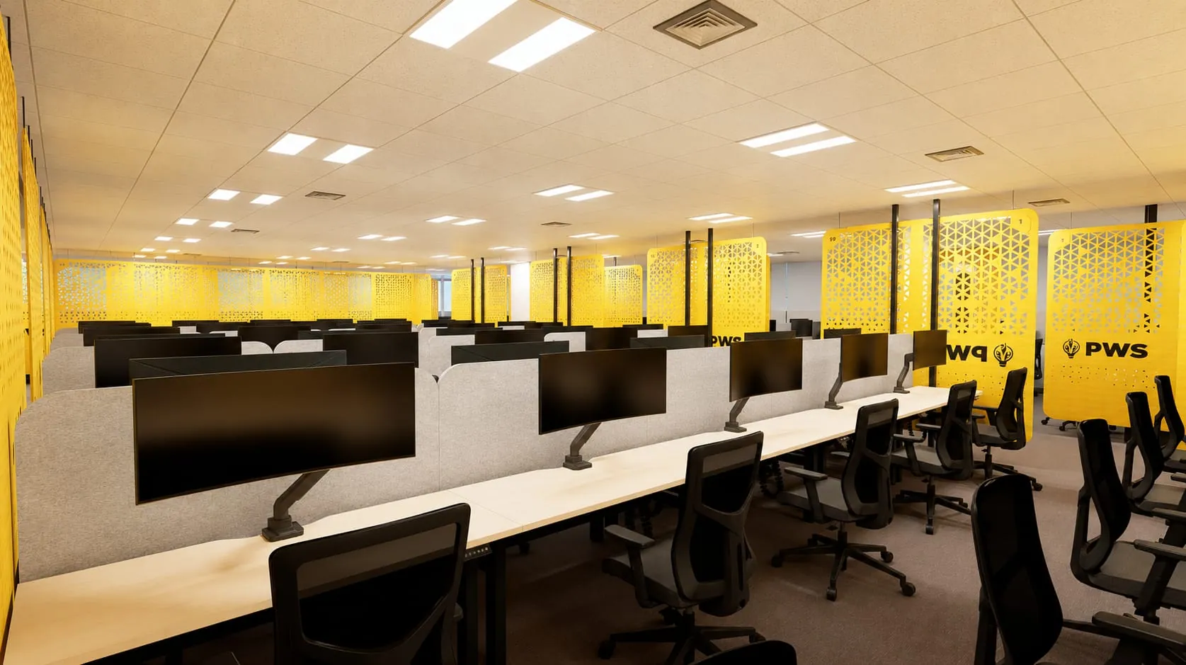 Wide view of desks with monitors and yellow partition walls in the open workspace