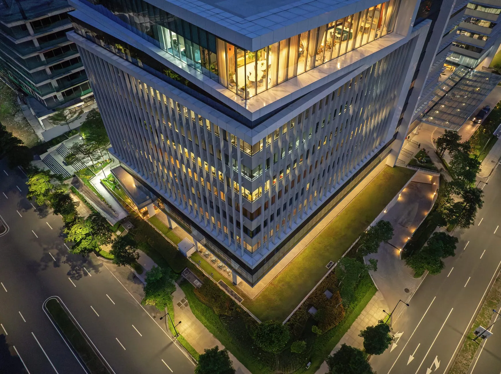 Close aerial view of a West Aeropark office building's lit rooftop terrace at dusk